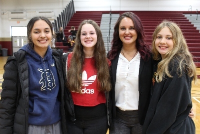 Four JPEC students are in the gym with their arms around one another